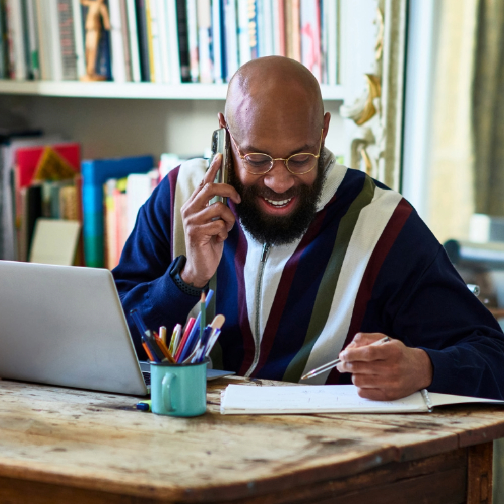 man at desk talking on cell phone