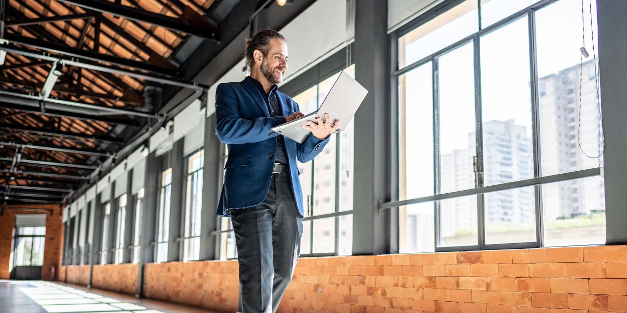 Investor walking through potential commercial property purchase with his laptop