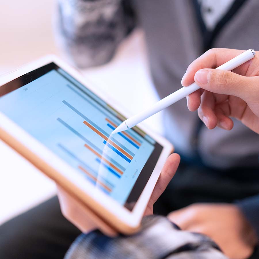 persona viewing tablet with a pen looking at financial charts